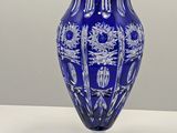 a blue vase sitting on top of a white table