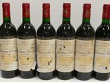six bottles of wine are lined up on a table