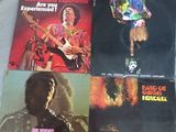 Quatre pochettes d'albums différentes des Rolling Stones sont posées sur un lit