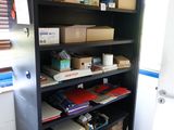 une bibliothèque noire sur laquelle sont posées de nombreuses boîtes