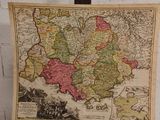 une vieille carte de l'Europe posée sur un support devant un mur de briques blanches