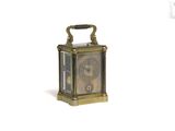une petite horloge posée sur une surface blanche