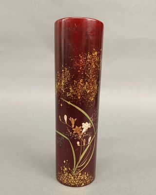 a red vase with gold and white flowers on it
