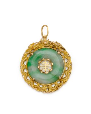 un pendentif en or et en jade vert orné d'un symbole chinois
