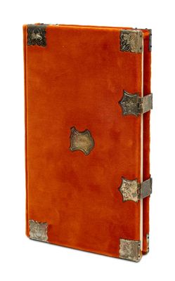 un carnet en cuir orange rehaussé de détails métalliques sur fond blanc