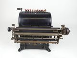 an old typewriter machine with a lot of tools on top of it