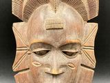 a wooden mask with a large head and a large face