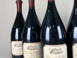 four bottles of wine are lined up on a table
