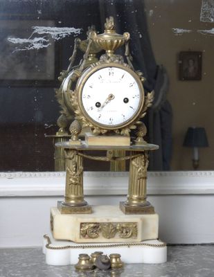 a clock that is sitting on a table in front of a window