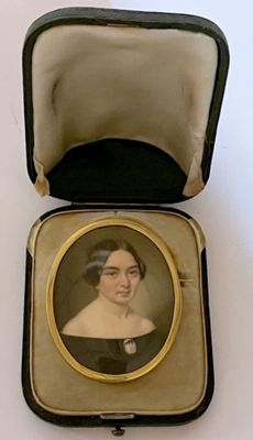 an old picture of a woman in a black dress in a case