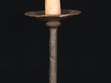 a small wooden candle holder with a candle on top of it