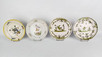 four plates with different designs on them sitting on a white surface
