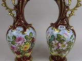 pair of vases with floral designs on them on a white surface