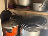 pots and pans are sitting on a shelf in a kitchen
