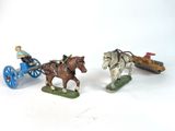 two figurines of horses pulling a carriage and a man on a horse drawn carriage