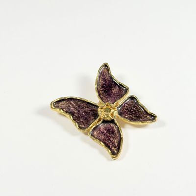 broche papillon en émail violet avec des touches dorées sur fond blanc