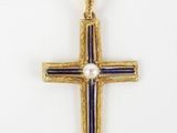 a gold cross with a pearl in the center on a white background