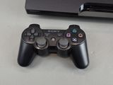 a video game controller sitting next to a sony game console