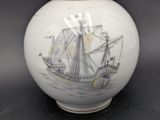 a white vase with a picture of a ship on it