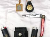 un couteau, un briquet, un étui à briquet et un porte-clés posés sur un drap blanc