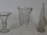 trois vases en verre posés l'un à côté de l'autre sur une table