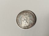 a close up of a silver coin with a crown on it