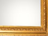 a gold framed mirror on a wall with a white background