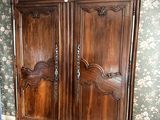 une grande armoire en bois dans le coin d'une pièce