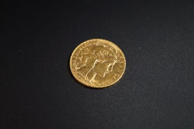 gros plan d'une pièce d'or sur une surface noire