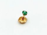 gros plan d'une bague en or avec une pierre verte