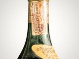 an old bottle of wine sitting on top of a table