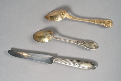 three silver spoons and two silver spoons on a table