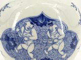 a blue and white vase sitting on a wooden stand