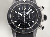 une montre noire avec un cadran noir sur fond blanc