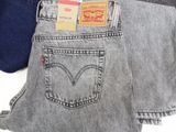 three pairs of levi ' s jeans are stacked on top of each other