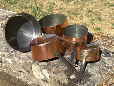 de nombreuses casseroles et poêles posées sur une dalle de pierre