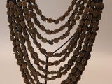 a close up of a necklace on a stand on a white background