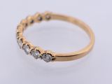 a close up of a gold and diamond ring on a white surface