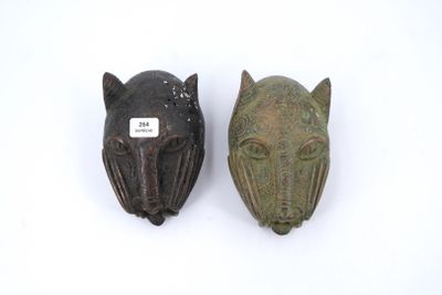 paire de têtes d'animaux sculptées sur fond blanc