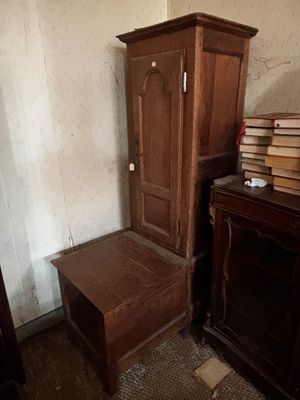 une grande armoire en bois et une petite table dans une pièce