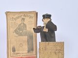 figurine of a man standing in front of a box with a book on it