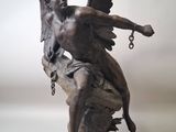statue of an angel on a rock with a chain around his neck