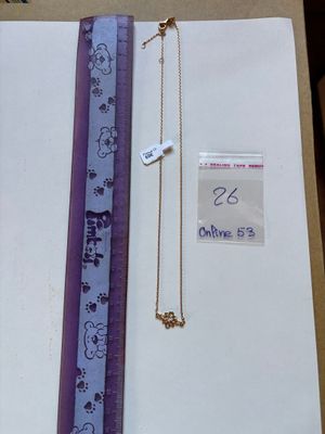 a purple ribbon and a necklace on a table