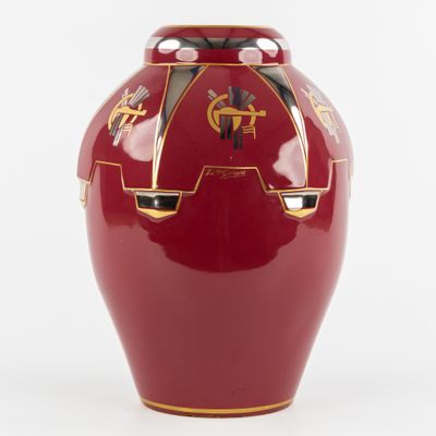 un vase rouge orné d'un motif doré