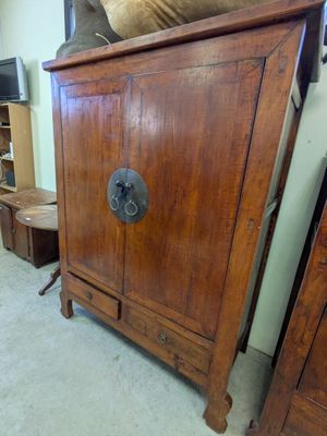 une armoire en bois sur laquelle est posé un ours en peluche