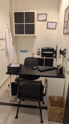 un bureau avec une chaise et un ordinateur portable posé dessus, dans une pièce