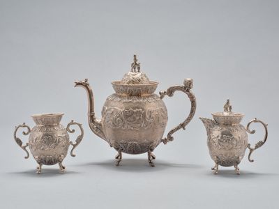 trois pièces en argent pour le thé et le café sur une table