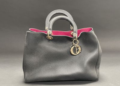 a grey and pink handbag with a gold charm on the handle