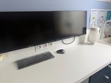 a desk with two monitors, a keyboard, and a mouse on it