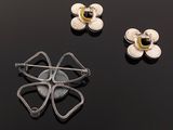 three pieces of jewelry on a black surface with a black background